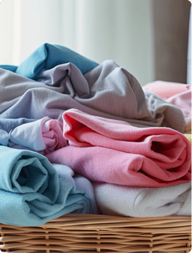 Stack of neatly folded pastel clothing inside a custom closet design basket.
