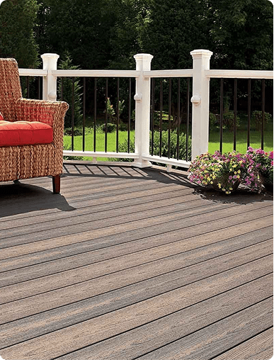 Premium wood composite deck floor with patio seating and a white storage railing.