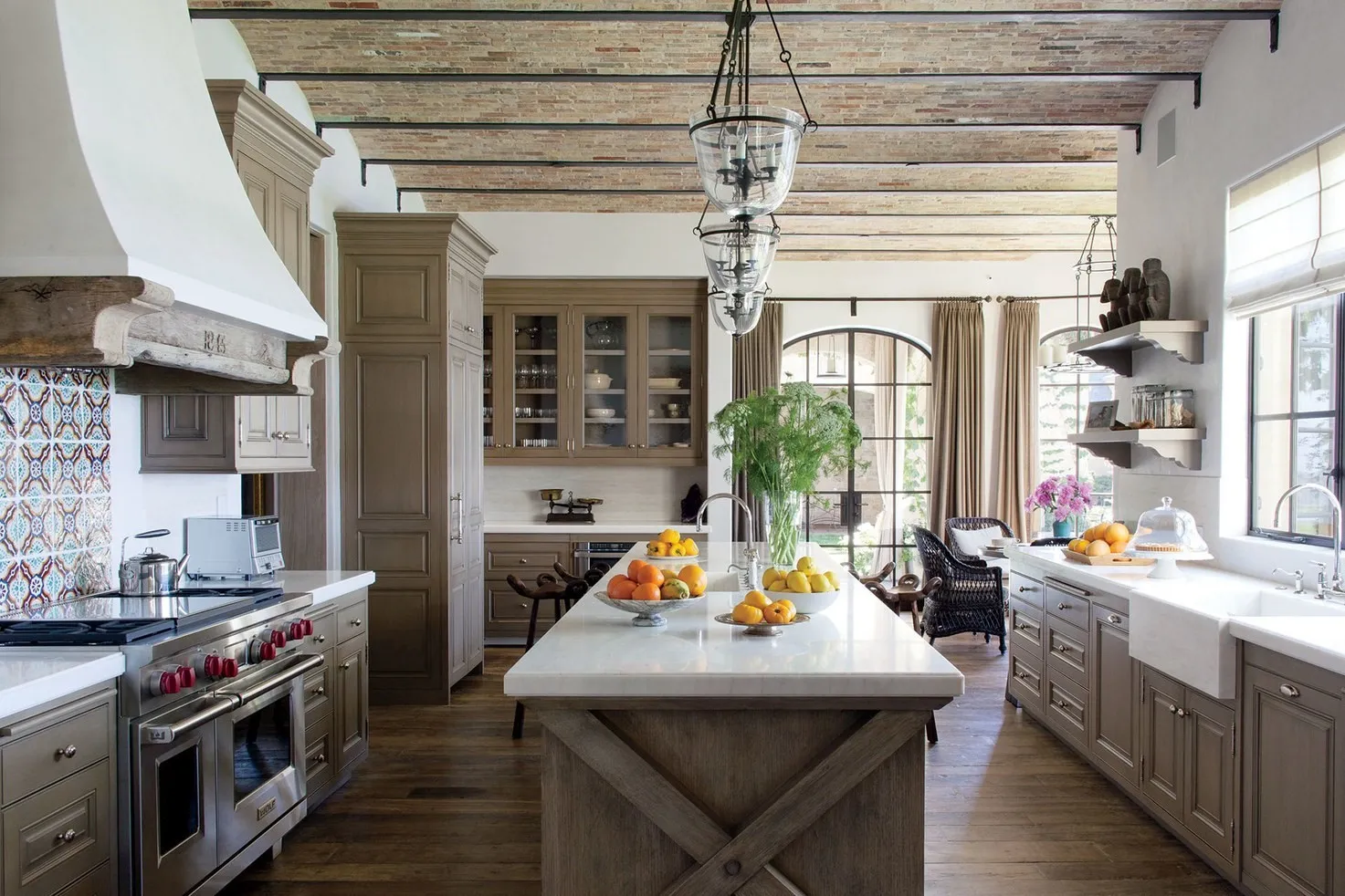 Spacious rustic kitchen with wooden cabinets, a large island, and exposed ceiling beams.